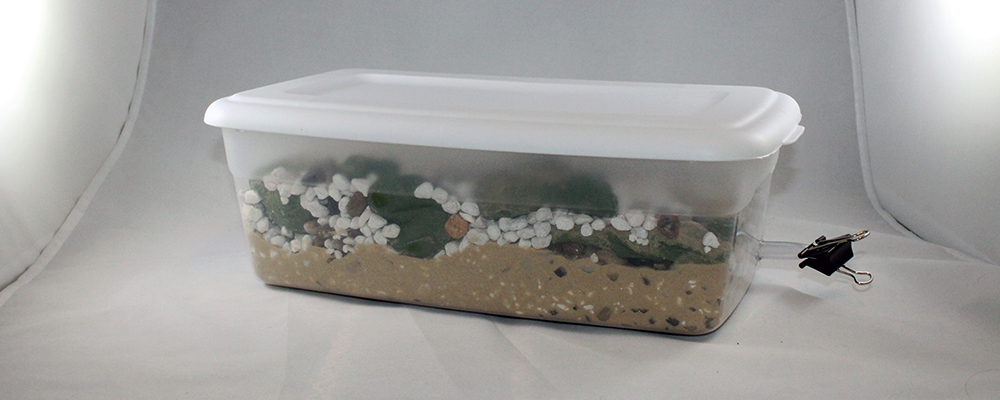 Science project is completed with rocks, sand and clay layered in the container. Science project is completed with rocks, sand and clay layered in the container.