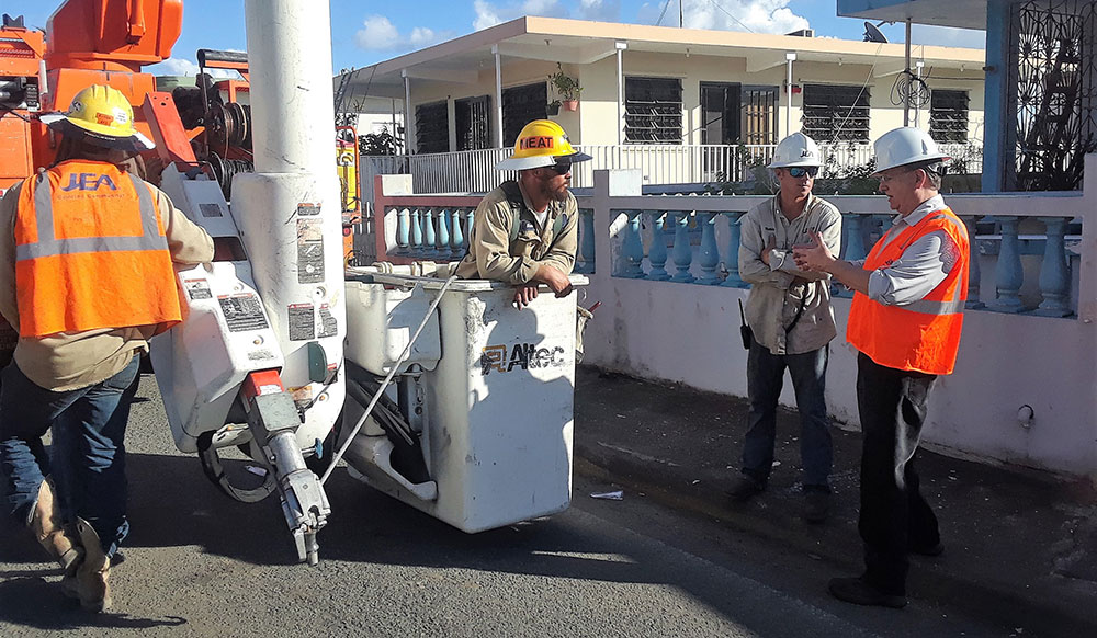 JEA CEO Paul McElroy (right) talks with a crew restoring power in Puerto Rico.