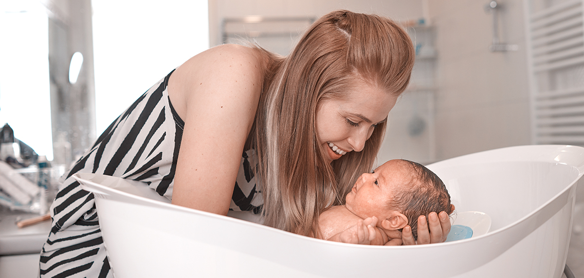 Woman bathing newborn
