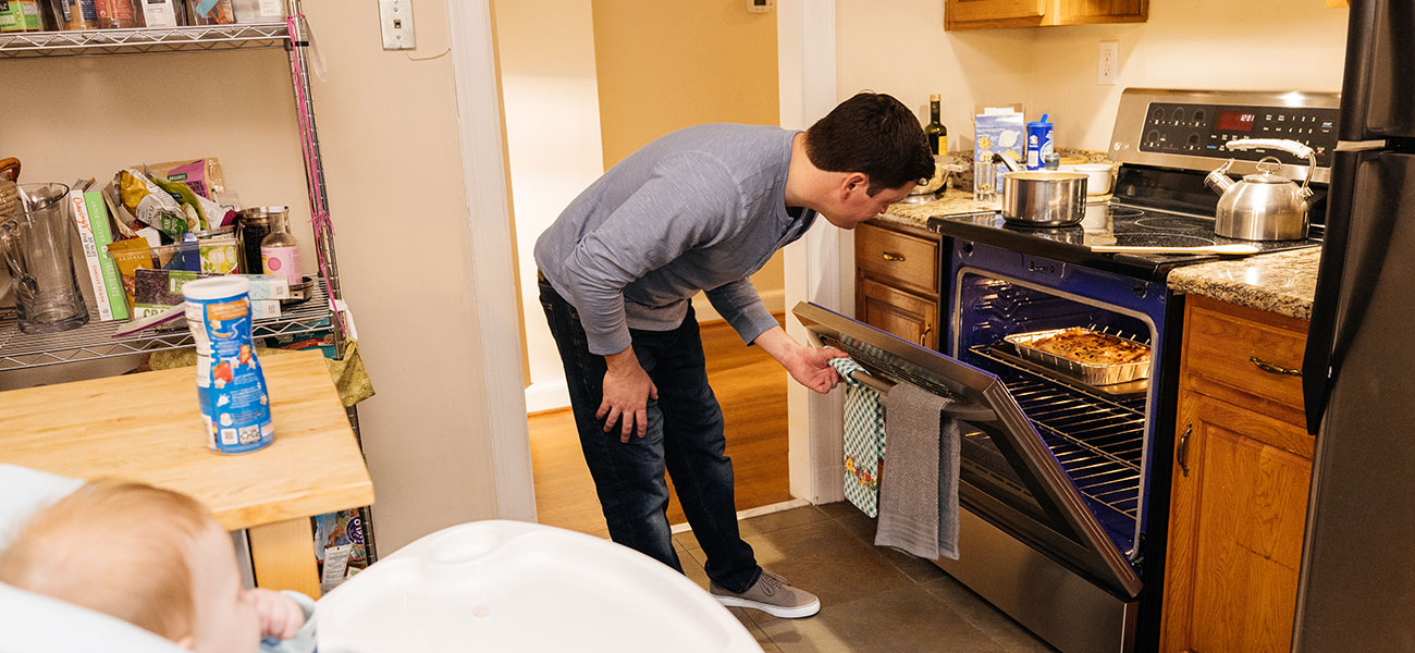 Man checking food in oven