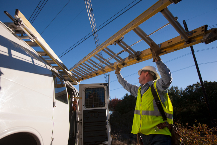 Construction worker with ladder Man loading ladder onto a work van