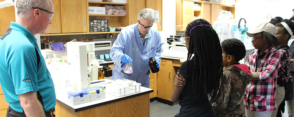 JEA Scientists showing students a lab